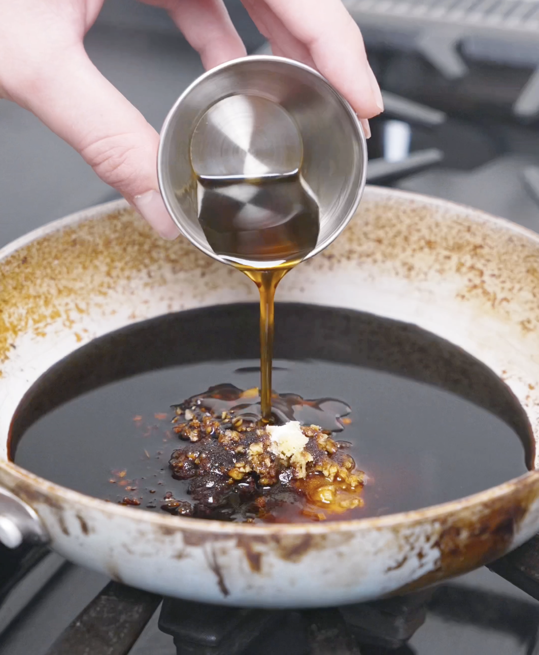Honey being poured into soy sauce, garlic, and ginger in a pan to build the sauce for Teriyaki Meatballs Recipe.