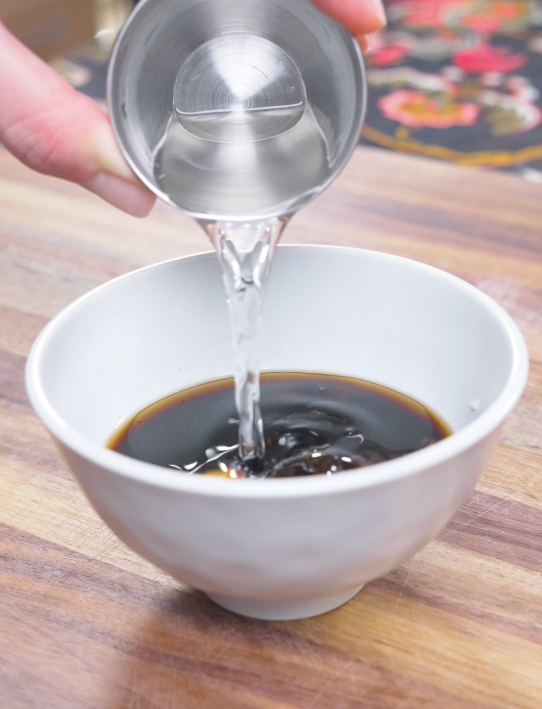 Sake being poured into soy sauce, honey, rice vinegar, and garlic to make the sauce for Japanese Steak Bowl Recipe.