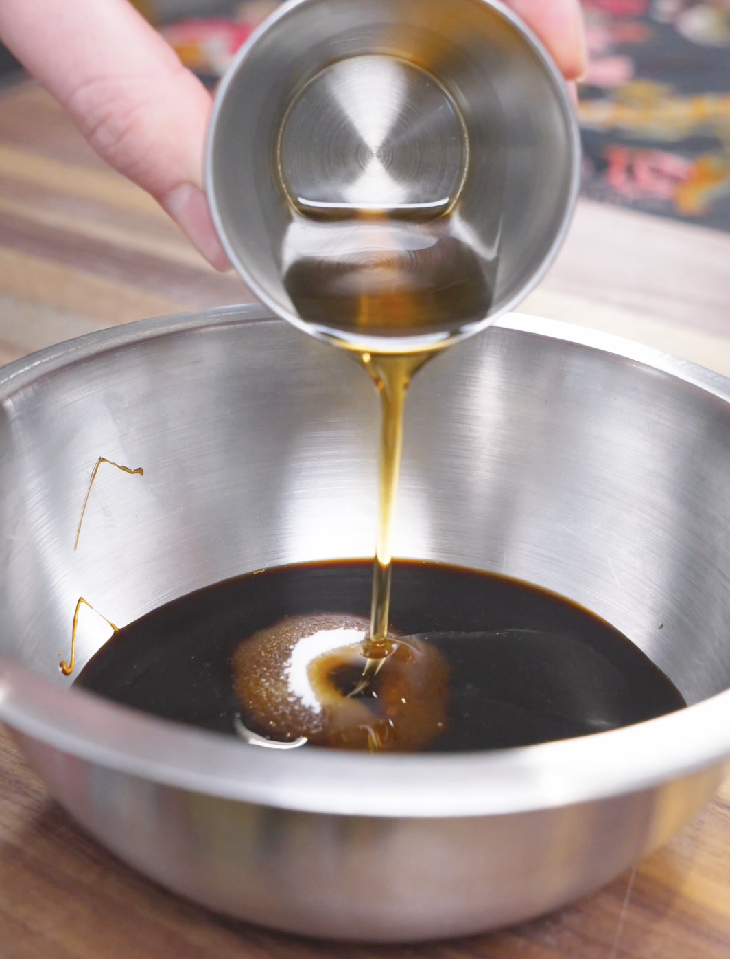 Sesame oil being poured into soy sauce, black vinegar, and hoisin for Kung Pao Chicken Noodles Recipe.