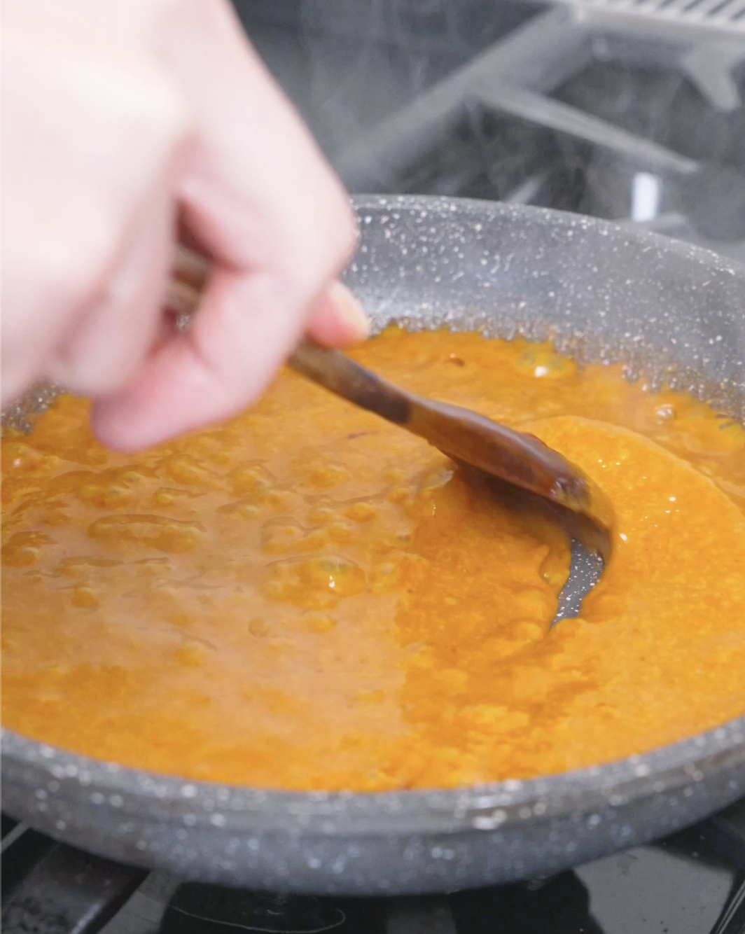The orange sauce bubbling and thickening until smooth and glossy for Creamy Gochujang Chicken Recipe.