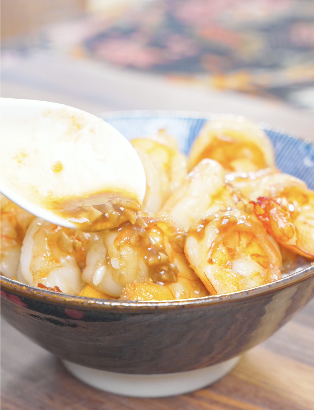 Extra garlic butter sauce being spooned over the shrimp in the bowl for Garlic Butter Shrimp Recipe.