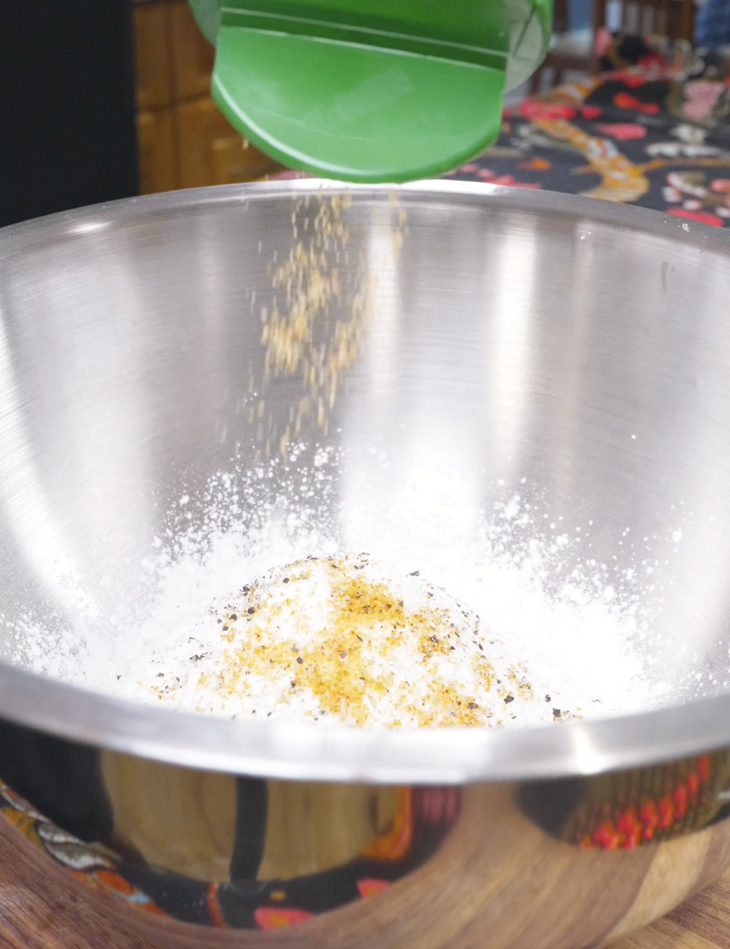 Garlic powder being added to flour, cornstarch, salt, and pepper for Crispy Fried Enoki Mushrooms Recipe.