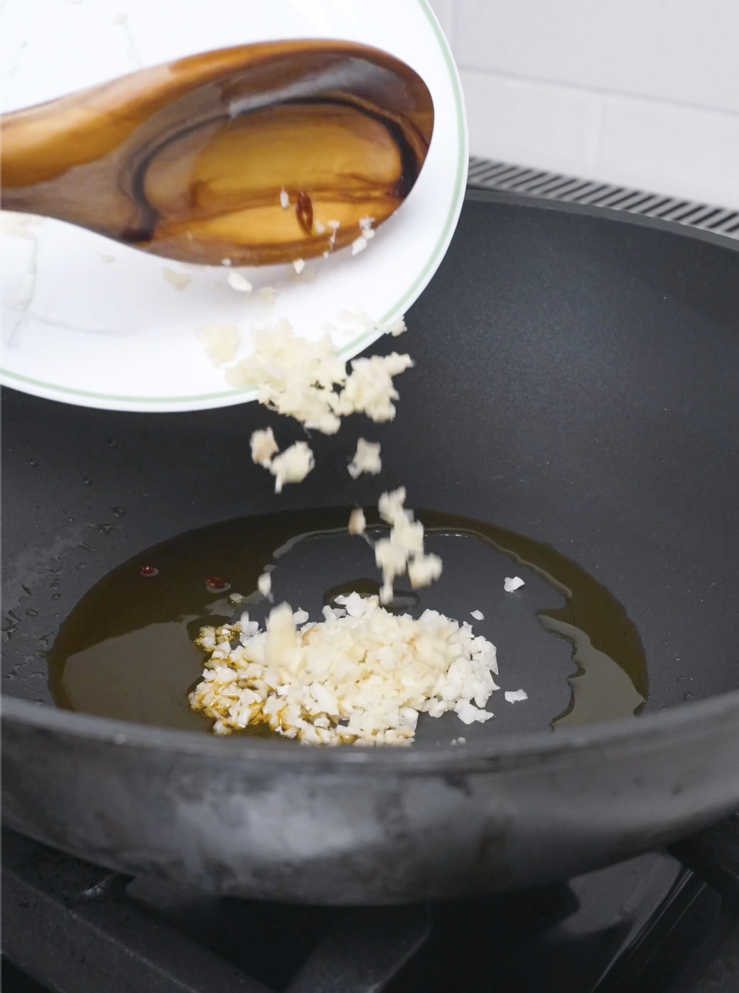 Minced garlic and ginger being added to the chili-infused oil for Mapo Tofu Recipe.