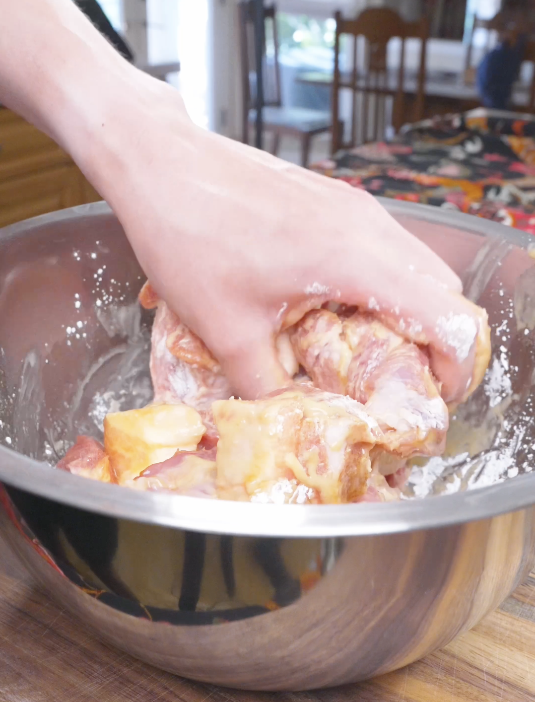 Pork belly cubes being mixed by hand until each piece is coated for Deep Fried Pork Belly Recipe.