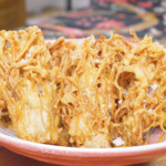 Finished Crispy Fried Enoki Mushrooms Recipe piled golden and craggy with flaky salt and black pepper.