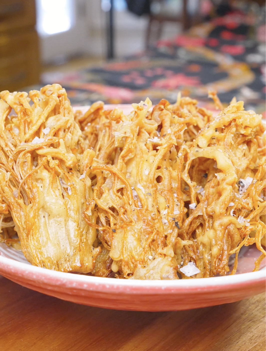 Finished Crispy Fried Enoki Mushrooms Recipe piled golden and craggy with flaky salt and black pepper.