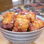 Finished Deep Fried Pork Belly Recipe in a bowl with deep caramel-brown crusted cubes and flaky salt.