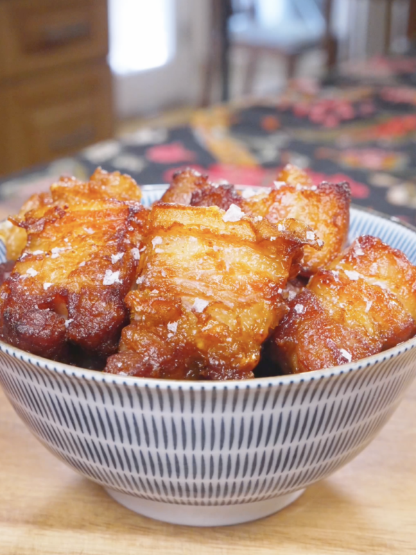 Finished Deep Fried Pork Belly Recipe in a bowl with deep caramel-brown crusted cubes and flaky salt.