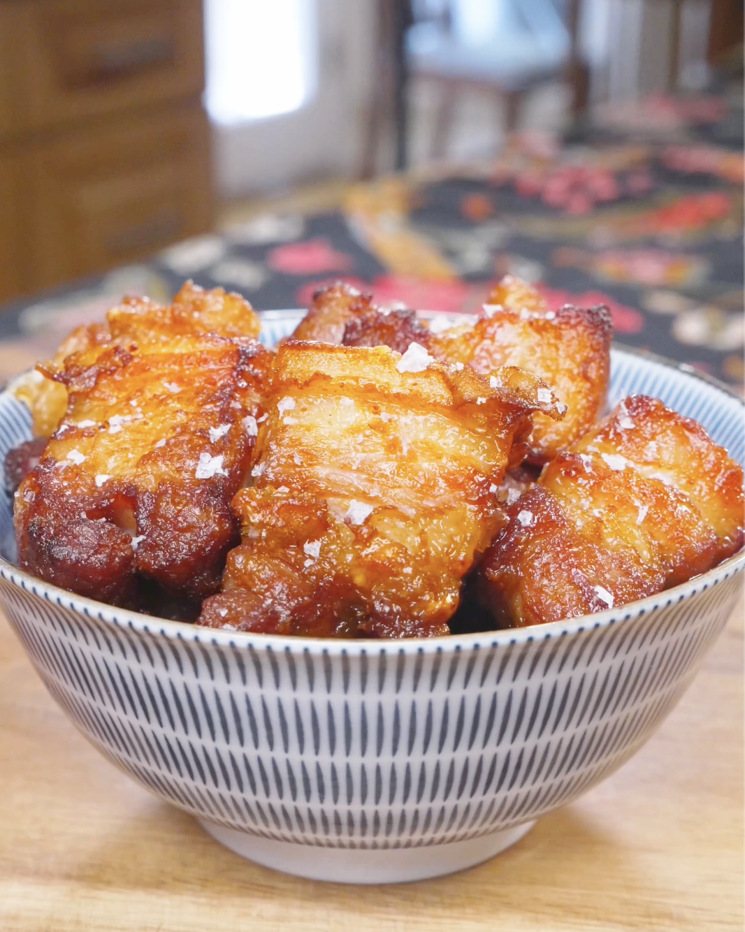 Finished Deep Fried Pork Belly Recipe in a bowl with deep caramel-brown crusted cubes and flaky salt.