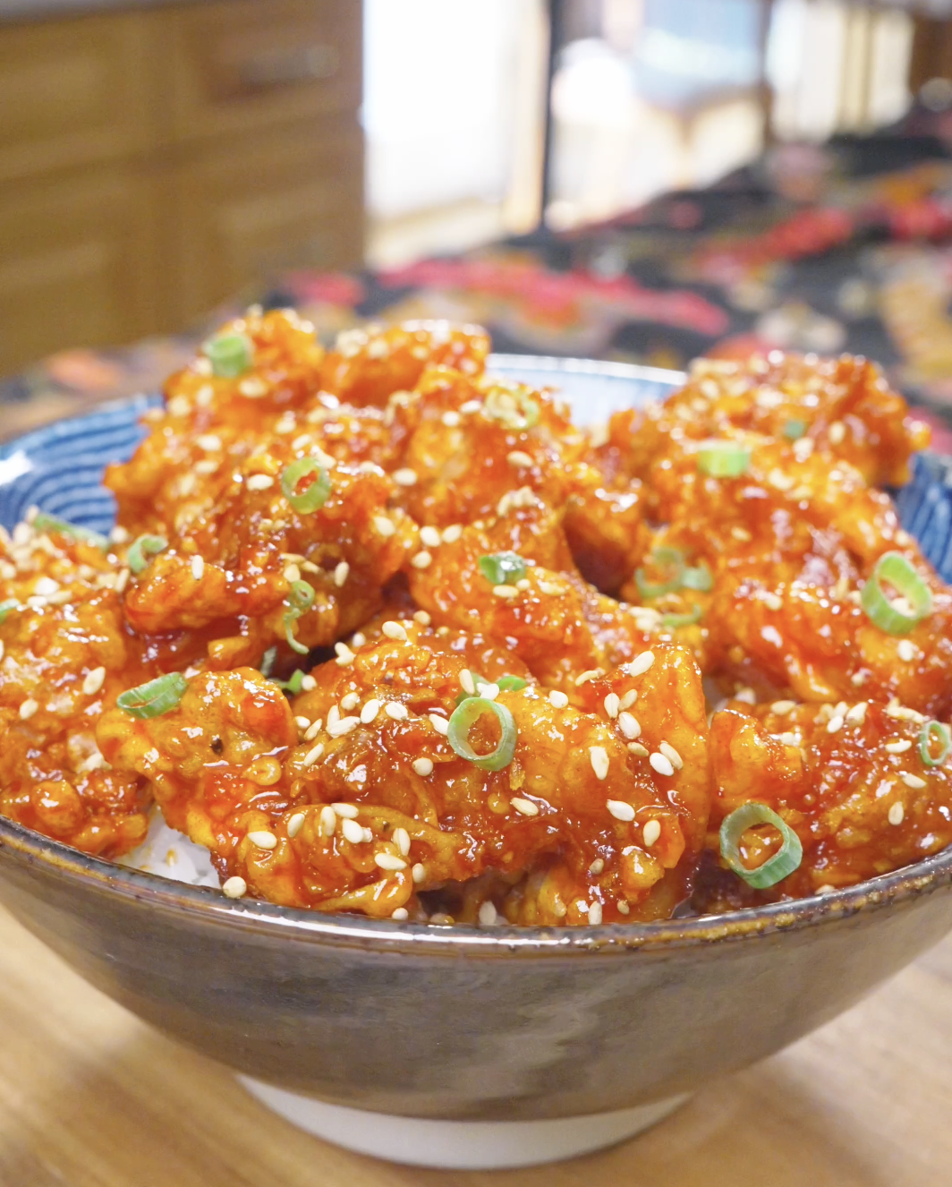 Finished Korean Popcorn Chicken Recipe over rice with sesame seeds and sliced scallions.