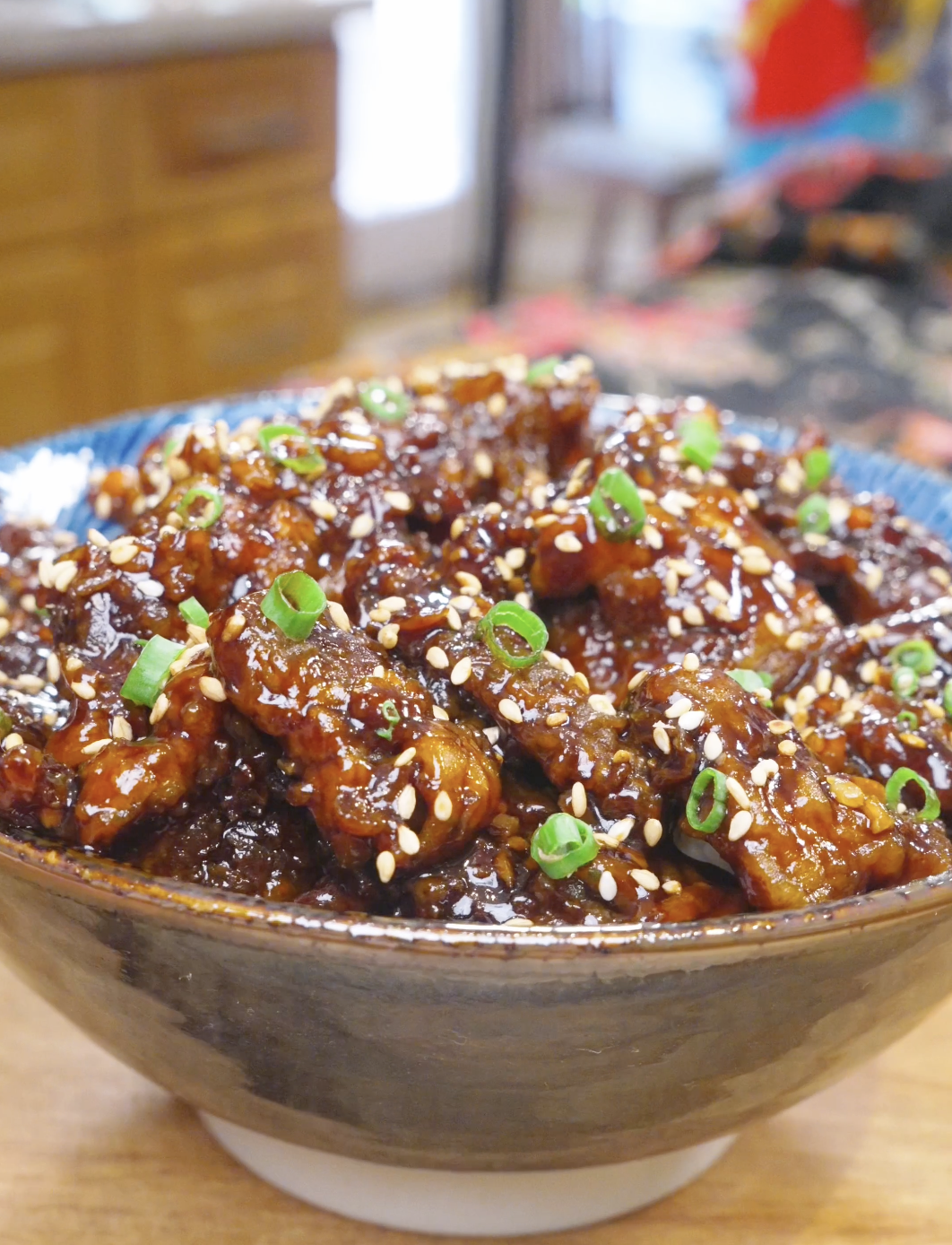 Finished Orange Beef Recipe in a bowl with crispy glazed beef, sesame seeds, and scallions.