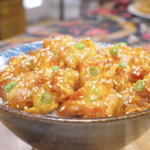 Finished Sweet Honey Fried Chicken Recipe over rice with sesame seeds and sliced scallions.