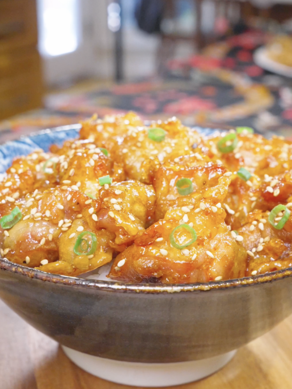 Finished Sweet Honey Fried Chicken Recipe over rice with sesame seeds and sliced scallions.