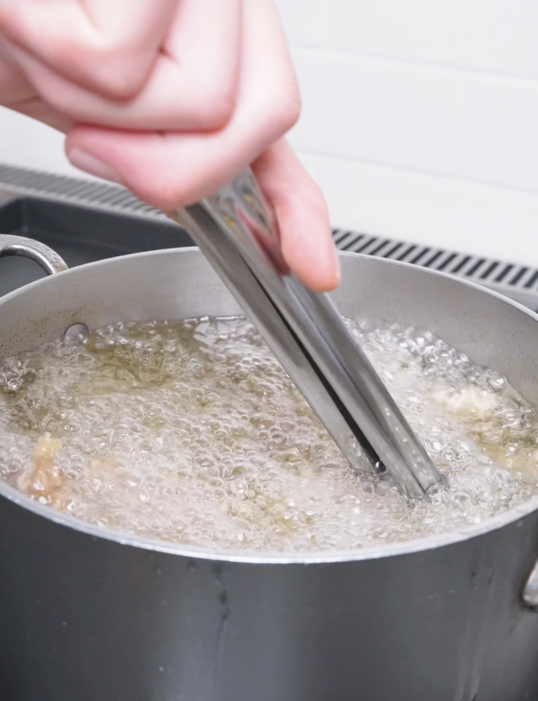Battered beef strips bubbling in a pot of hot oil for Orange Beef Recipe.